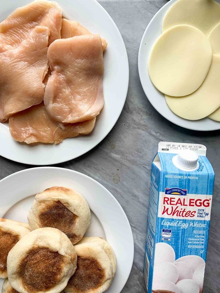 These are copy cat chick-fil-a egg white grills. There are 6 sandwiches stacked on a plate. The sandwich has an english muffin, cheese, egg white patty, and chicken breast.