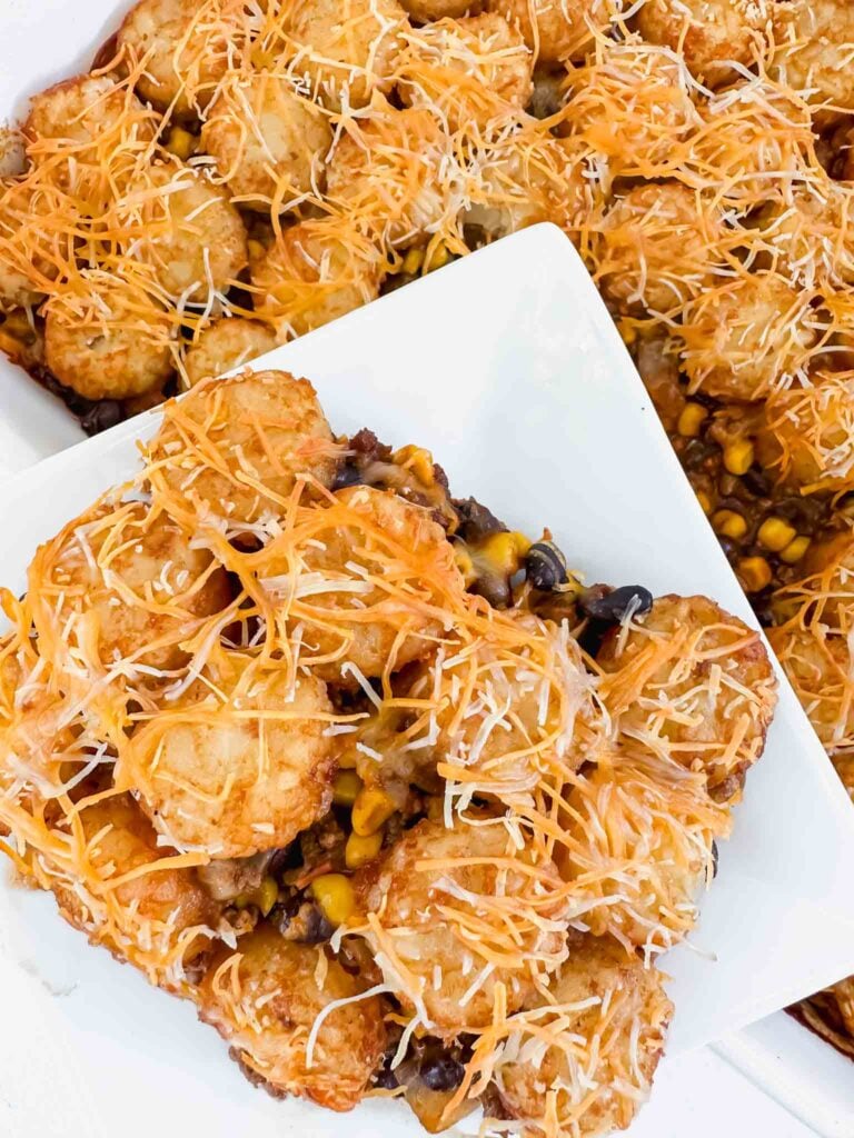 Plate with mexican tater tot casserole in front of dish