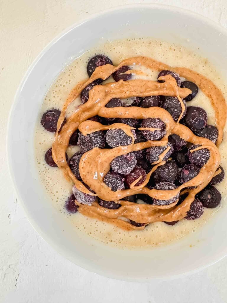 Bowl of protein powder oatmeal with berries and peanut butter