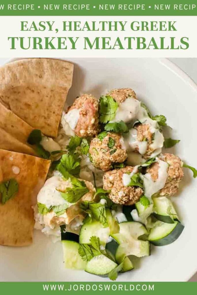 This is a pinterest pin of greek turkey meatballs. There's a bowl filled with white rice, greek meatballs, cucumbers, hummus, and pita. It's topped with a tzaziki sauce.