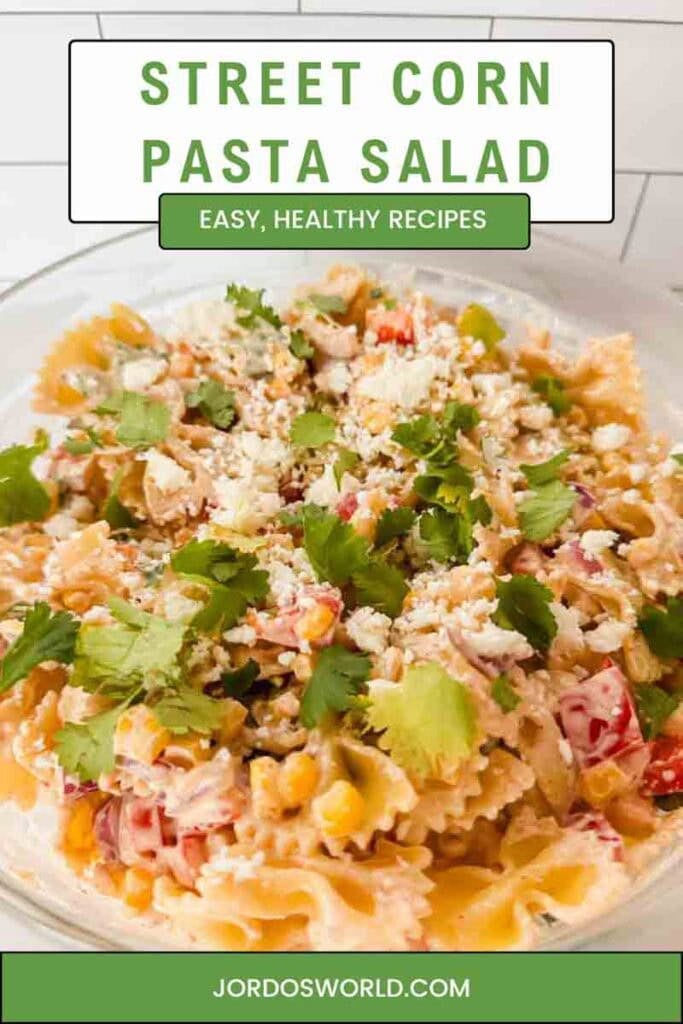 This is a pinterest pin of street corn pasta salad. There's a large bowl filled with the pasta salad of noodles, corn, peppers, cheese, sauce and topped with cilantro. The title of the recipe is above the picture.